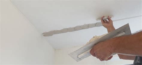 Detail van een stucadoor die skim coating aanbrengt met een roller.