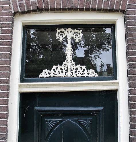 Illustratie: Levensboom als gietijzeren ornament in een bovenlicht