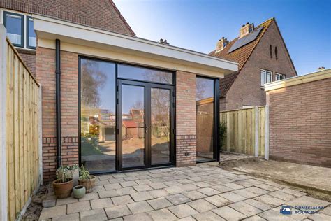Illustratie van een huis met diverse renovatie-opties, zoals een aanbouw, nieuwe kozijnen en gevelreiniging.