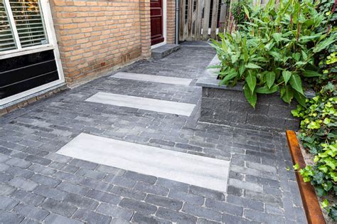 Groene wand langs pad naar voordeur en losse stenen stapstenen