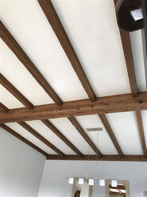 Praktische foto van houten plafondbalken in een modern interieur
