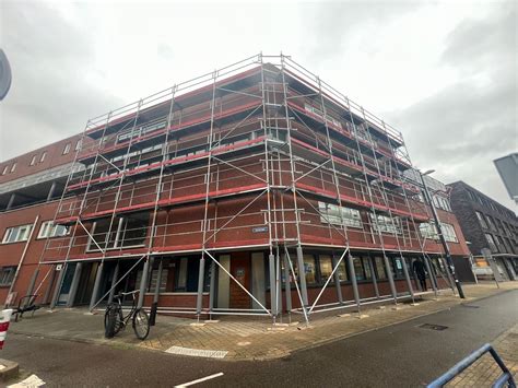 Steiger rondom een flatgebouw voor balkonrenovatie