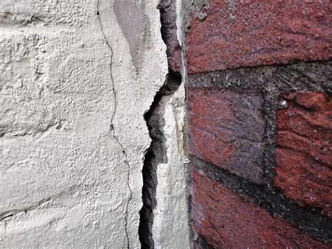 illustratie van een beschadigde muur die gerepareerd wordt door een stukadoor