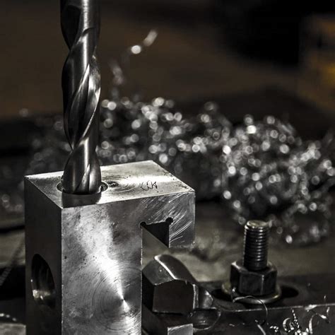 Diagram dat het boren van een geleidegat in metaal illustreert.