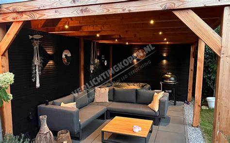 Foto van een terras met verschillende lagen verlichting: wandlampen, grondspots en LED-strips