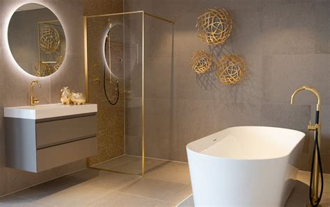 Badkamer met gouden accenten zoals een kraan en accessoires