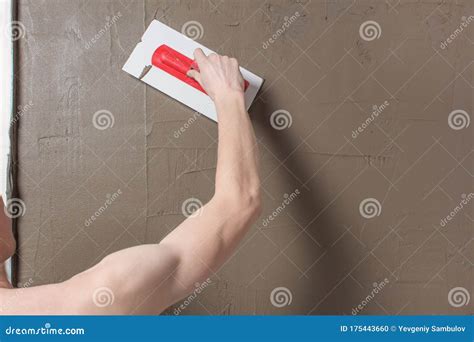 Illustratie van het aanbrengen van tegellijm met een lijmkam.