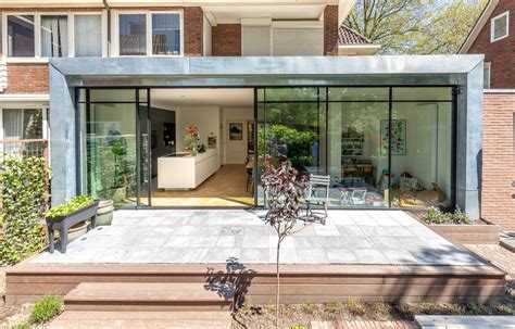 Illustratie van een moderne, glazen klompenhok aanbouw naast een woning