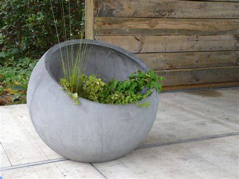 Foto: voorbeeld van een betonnen bloempot in een tuin