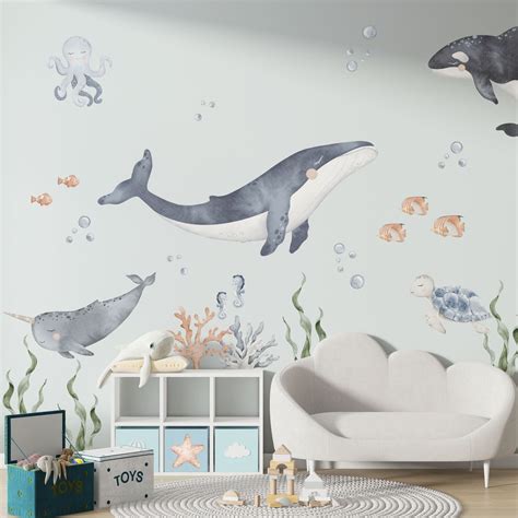 Een kinderkamer met het onderwater behang, waar de muren versierd zijn met zeedieren, wat zorgt voor een speelse en magische sfeer.