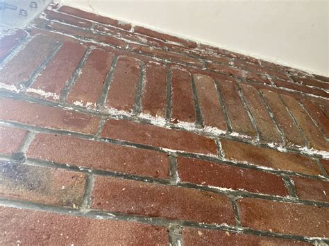 Voor en na foto van een bakstenen gevel na het verwijderen van verf, waarbij het voegwerk intact is gebleven.