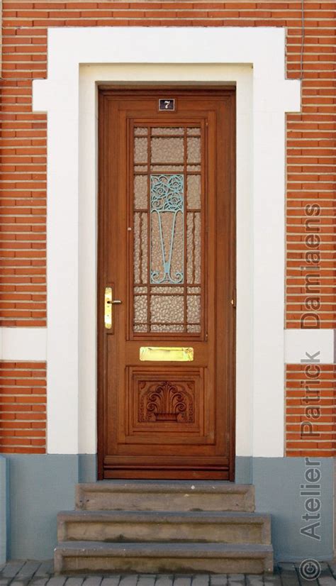 Art Deco voordeur met geometrische reliëfs en messing details