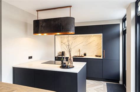 Stijlvolle keuken met een mat zwart keukenblad en gouden accenten