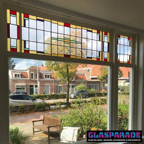 Rond glas-in-lood-ramen en ornamentiek op jaren 30 voordeuren als visueel hoogtepunt