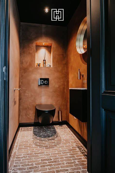 Afbeelding: voorbeeld van donker behang met zwarte tegels en wit sanitair in een toiletruimte