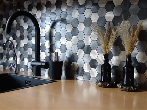 Verschillende soorten zelfklevende mozaïekstrips en tegels, waaronder hexagon- en visgraatpatronen in diverse kleuren en materialen.