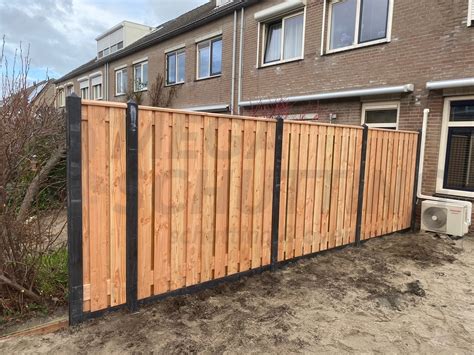 Detailfoto van een afdeklat op een schutting, met pijlen die de waterafvoer aangeven.