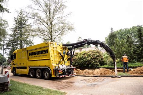 afbeelding van een zuigwagen met slangen die grond afvoeren