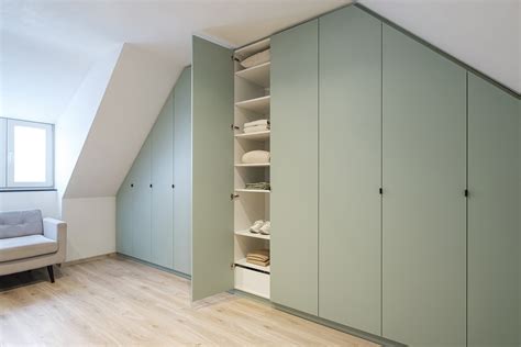 Voorbeeld van een op maat gemaakte houten kast in een slaapkamer met schuin dak
