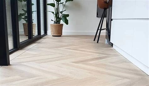 Detailfoto van de overgang tussen een visgraatpatroon, een band en een smalle bies op een PVC vloer.