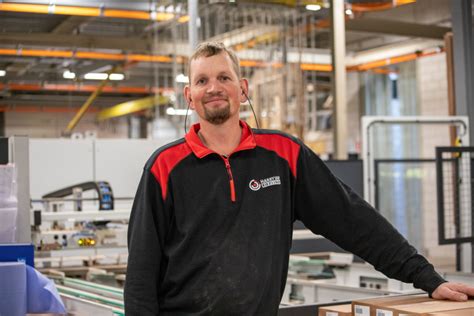 Een overzicht van de moderne fabriekshal van Harryvan Kozijnen, met machines en medewerkers aan het werk.
