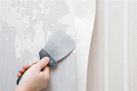 afbeelding van een plamuurmes dat behang van de muur schraapt