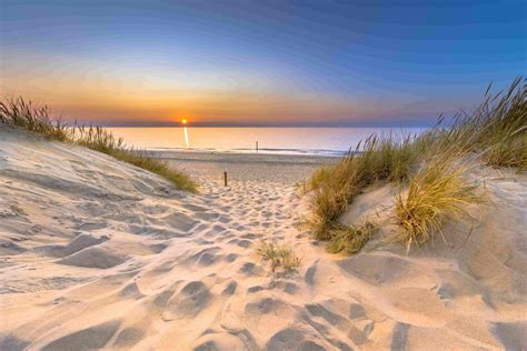 Foto van de kustlijn van Sint Maartenszee met duinen en het strand