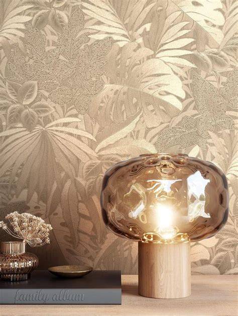 Beeld van vliesbehang tropisch taupe goud met palmbladeren en bloemmotieven