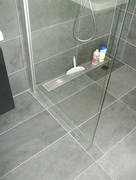 voorbeeld van een betegelde douchevloer met een glazen douchewand