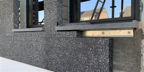 Foto van een strak afgewerkte buitenmuur met stucwerk