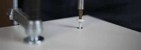Illustratie van de juiste manier om Trespa platen te schroeven met een centraal fixatiepunt en grotere gaten voor uitzetting.