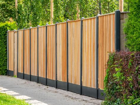 Hardhouten tuinschermen in combinatie met antraciet betonpalen en platen.