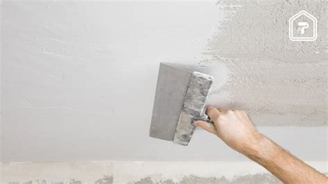 Stukadoor die een muur glad afwerkt met een troffel