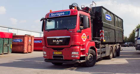 Foto van een vrachtwagen die paardenmest ophaalt bij een paardenhouder.