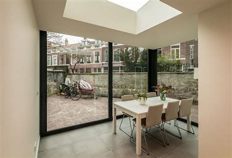foto van een moderne aanbouw die strak aansluit op een bestaande muur