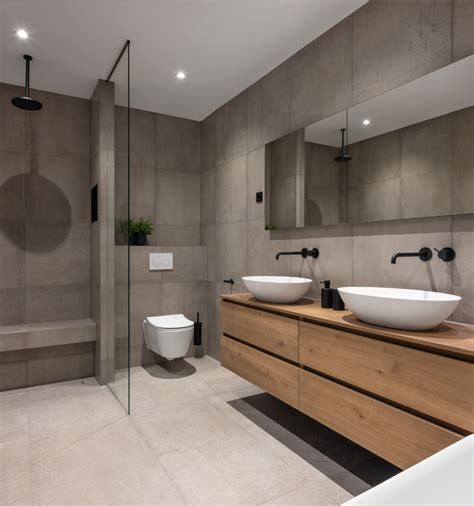 Voorbeeld van een industriële badkamer met betonlook tegels, houten meubel en zwarte stalen douchewand
