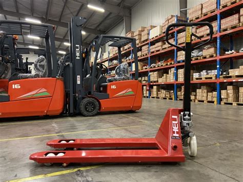 Foto van een industriële heftruck die over een moderne magazijnvloer rijdt.
