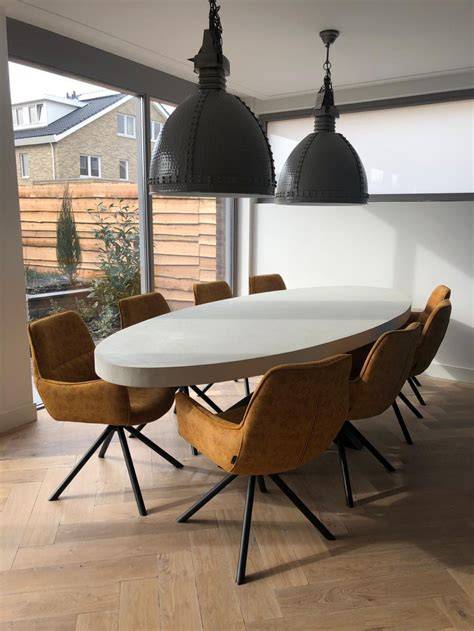 Industriële eetkamerstoel naast betonlook eettafel