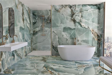 Afbeelding: Onyx marmerlook tegels in combinatie met goudkleurige waterkraan