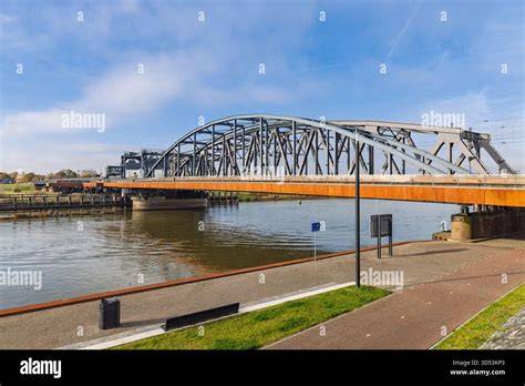 Verlichte houten-achtige bank langs de Oude IJsselbrug met waterzicht