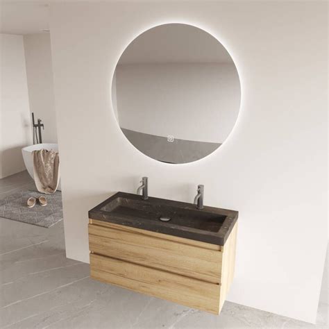 Een strakke, moderne badkamer met een zwevend badkamermeubel en een ronde spiegel met verlichting.