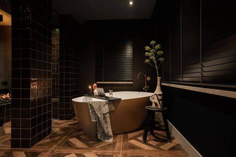 Afbeelding van een hotel chique badkamer met vrijstaand bad en donkere accenten