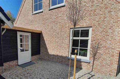 Infographic: factoren die de prijs van een achterdeur met kozijn beïnvloeden (materiaal, beglazing, kozijntype, afwerking).