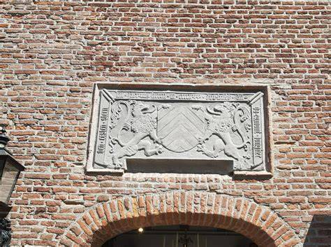 Historische gevelsteen 'AL NIET' nabij het gildehuis, een voorbeeld van verzamelden erfgoed