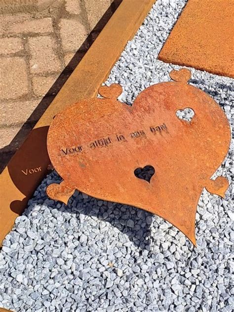 Close-up van een naambordje van cortenstaal met een roestige patina