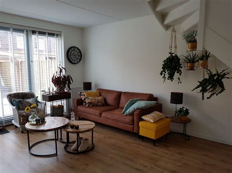 Woonkamer met botanische planten en houten accenten