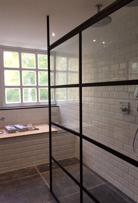 Voorbeeld van een donkere, industriële badkamer met glazen douchewand en zwarte profielen