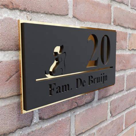 Afbeelding van een roestvrij stalen naambordje met matte zwarte coating aan een stenen muur