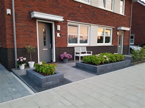 Foto: middelgrote voortuin met lange tegels en plantenbak