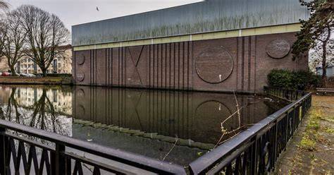 Beeld van de vernieuwde gevel met tien meter hoge glazen entreepartij en zichtbare trappen in glazen balustrades